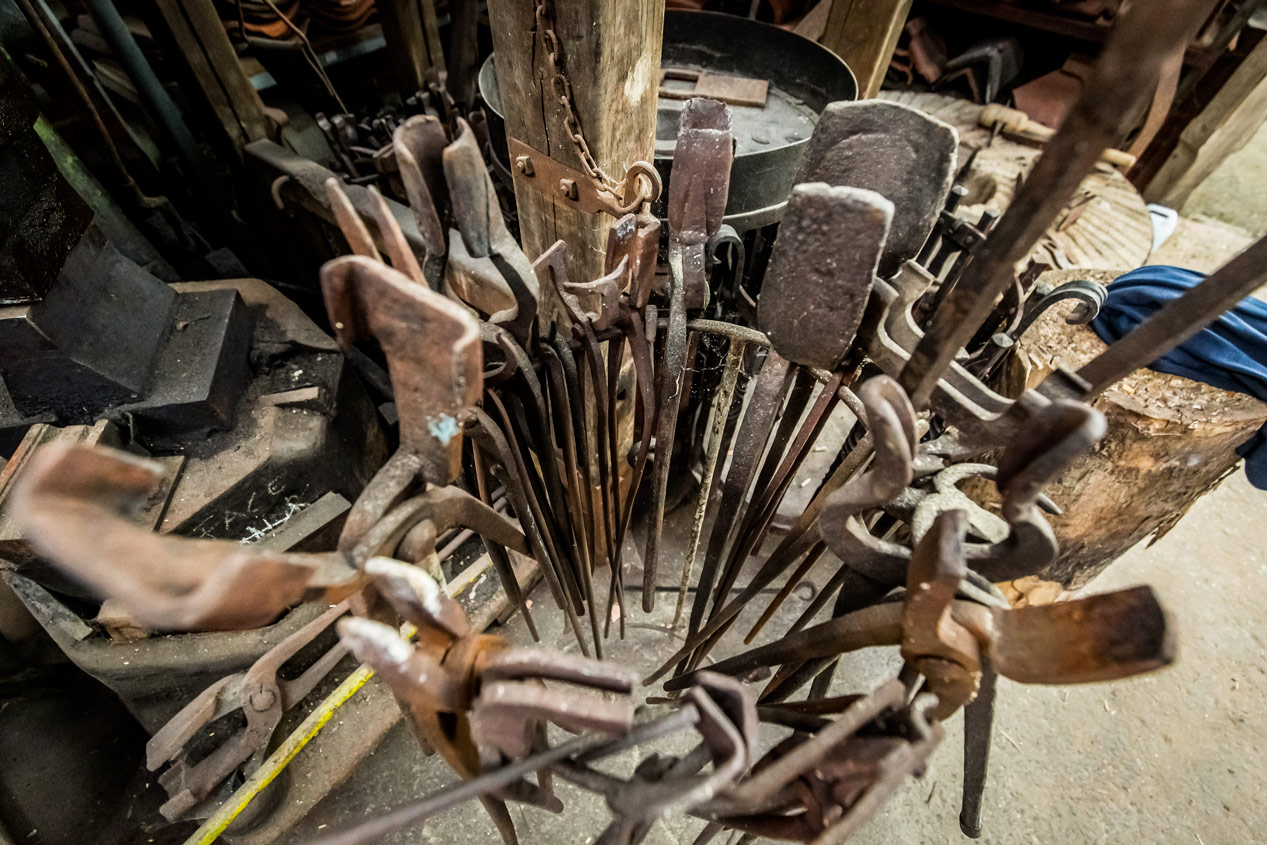 Collection d'outils de forge disposés en cercle autour d'un poteau