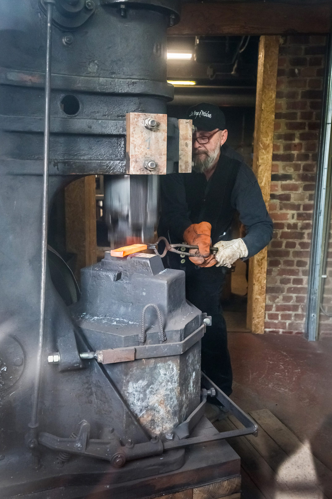 Forgeron au marteau-pilon travaillant le métal incandescent