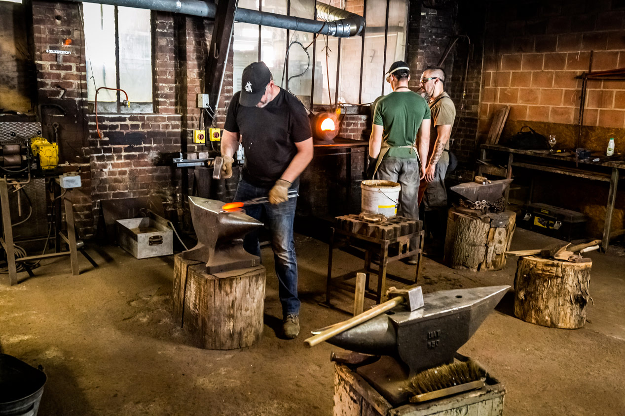 Stagiaire transportant du métal incandescent avec des pinces