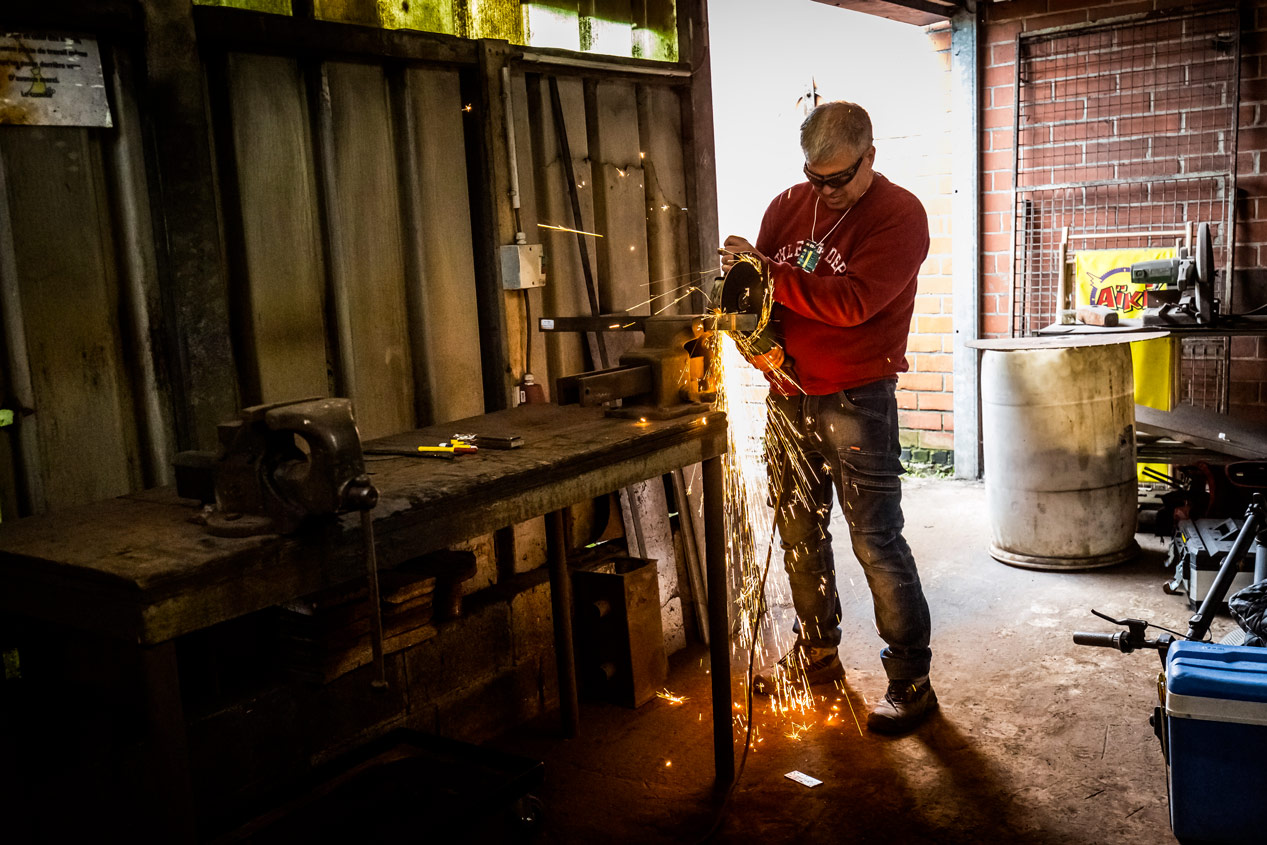 Artisan meulant une lame de couteau avec gerbe d'étincelles