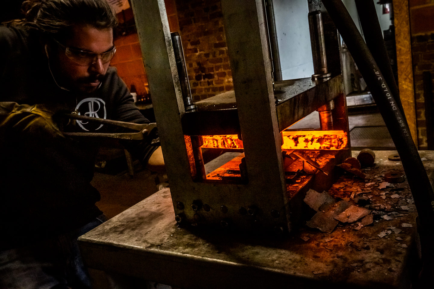 Presse hydraulique écrasant un bloc de métal incandescent